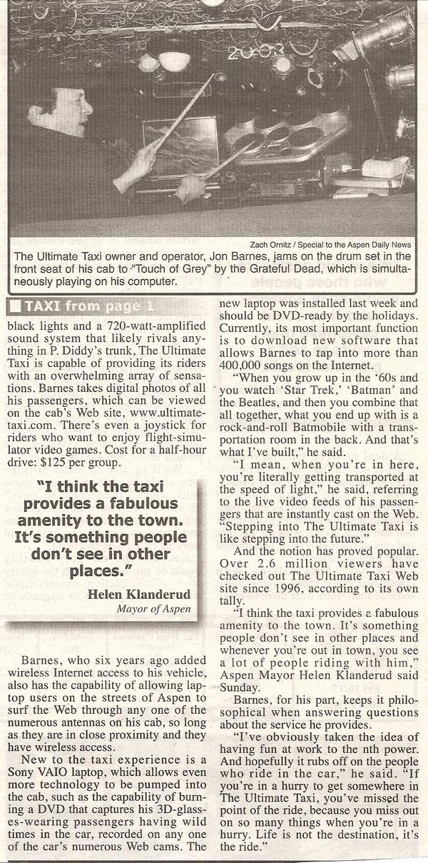 The Ultimate Taxi owner and operator, Jon Barnes, jams on the drum set in the front seat of his cab to Touch of Grey by the Grateful Dead, which is simultaneously playing on his computer.